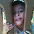 Little boy looking out of playset
